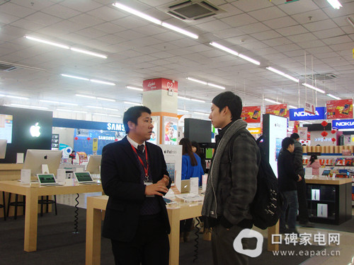吴克店长（左）向我们介绍国美优势